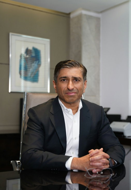 a-man-in-a-suit-poses-in-an-office.jpg A man in a suit poses in an office
