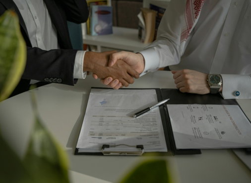 two-people-shaking-hands-over-a-piece-of-paper.jpg two people shaking hands over a piece of paper
